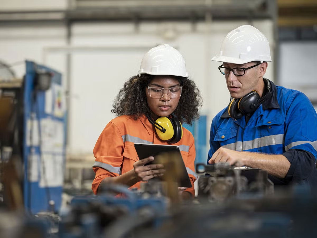 Two engineers working together on a tablet