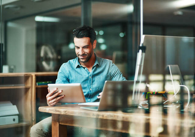 Man sitting at a Café holding a tablet