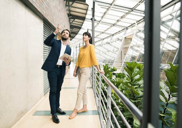 Man and woman talking and working on tablet