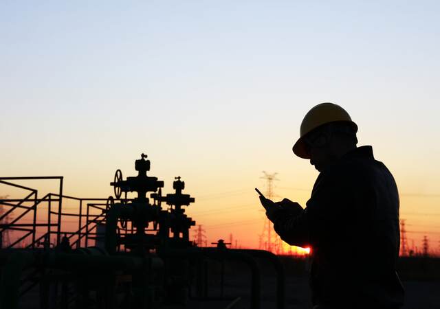 sunset and a worker holding a phone