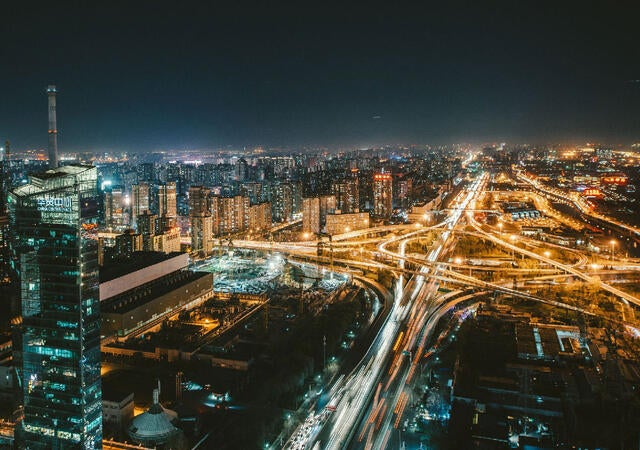 Lit city skyline with highways at night