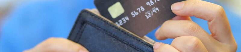 Person putting a credit card into a wallet