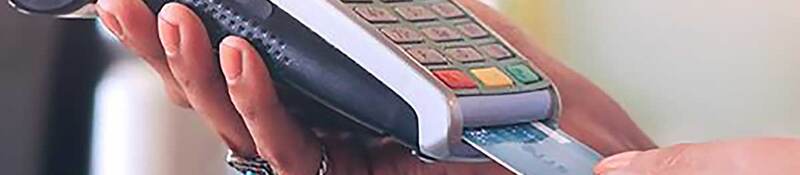 Person inserting a credit card into a handheld card reader