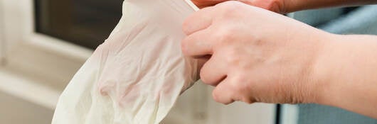 A person putting on latex gloves