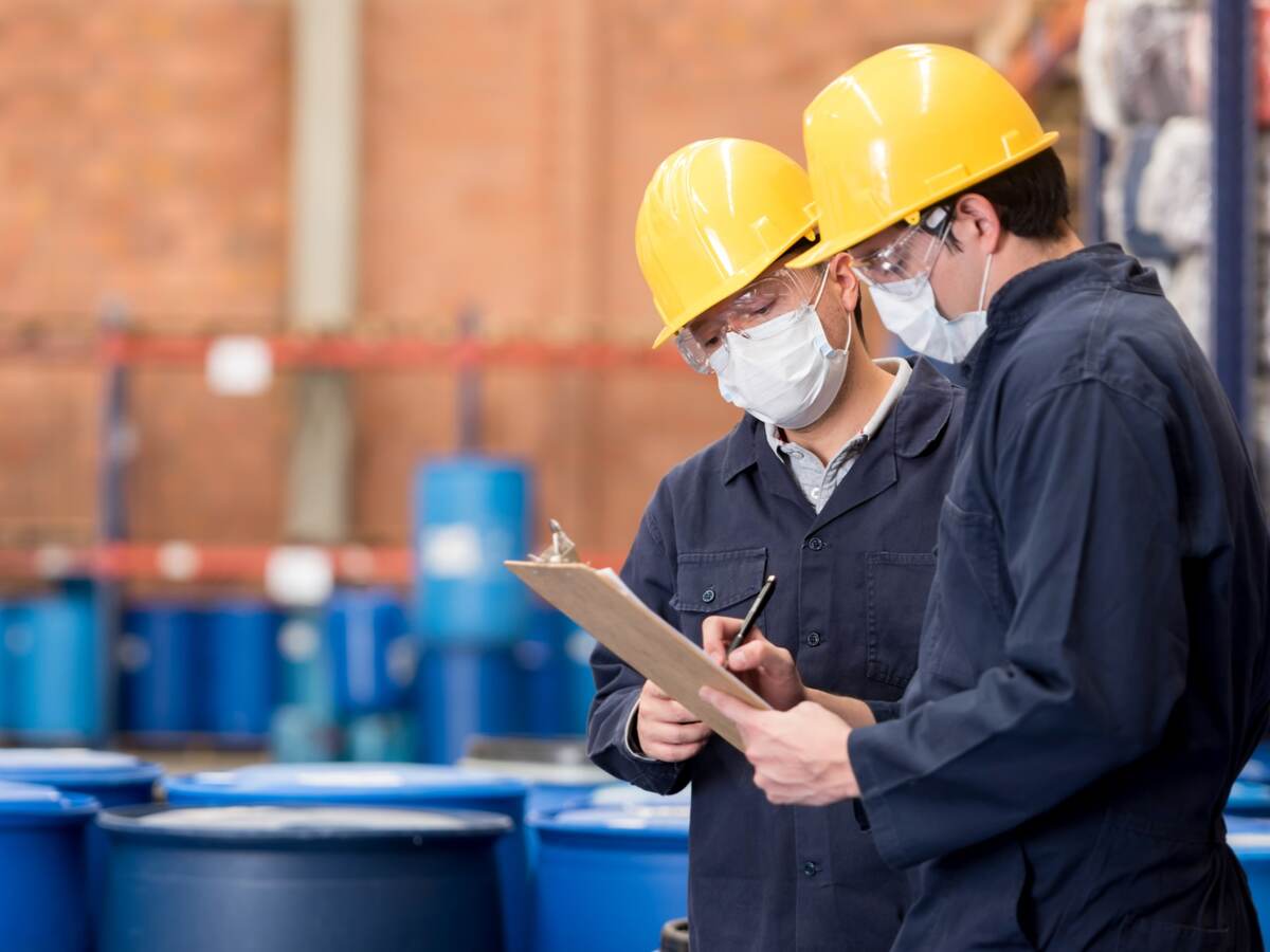 Two employees having a discussion and looking at a chart in a chemical plant