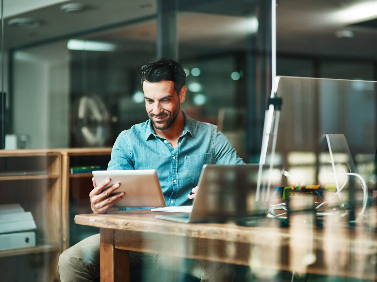 Man sitting at a Café holding a tablet