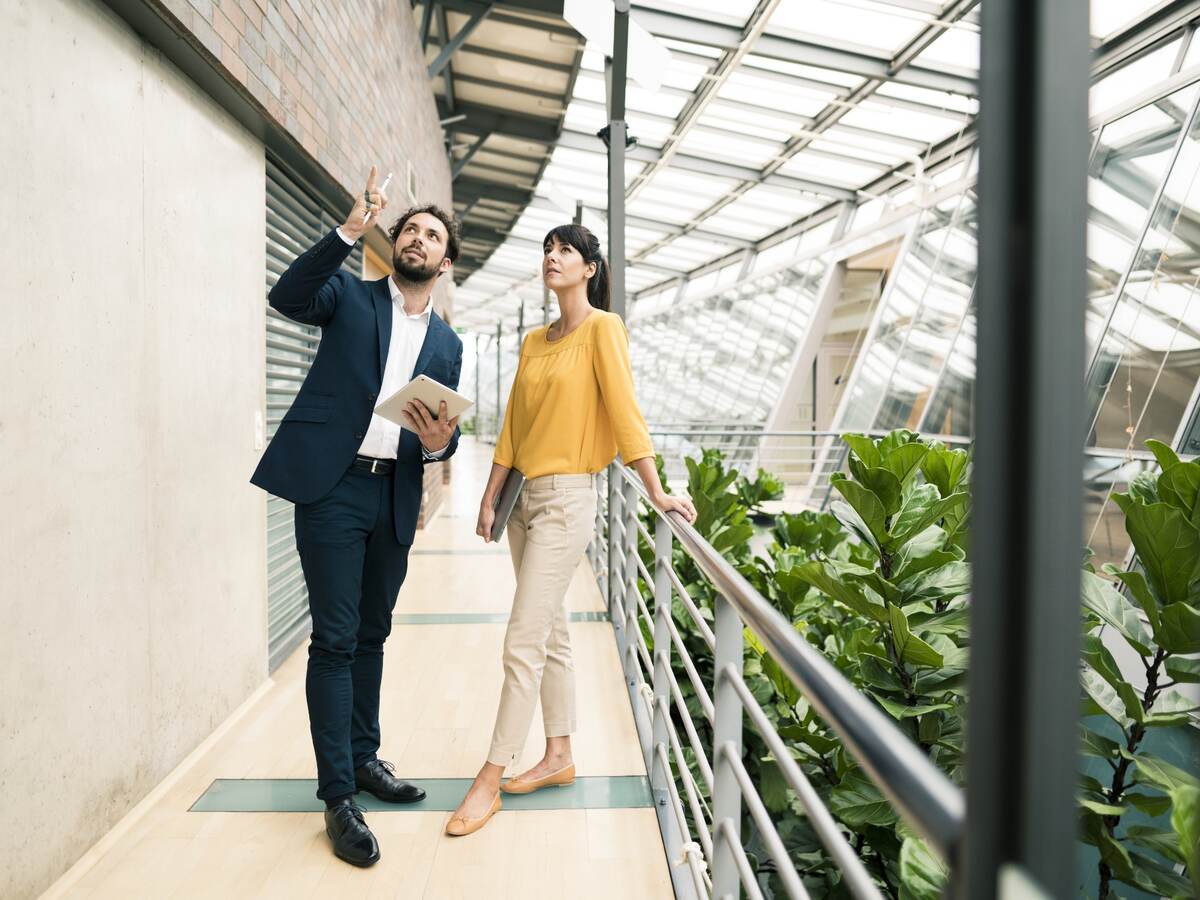 Man and woman talking and working on tablet