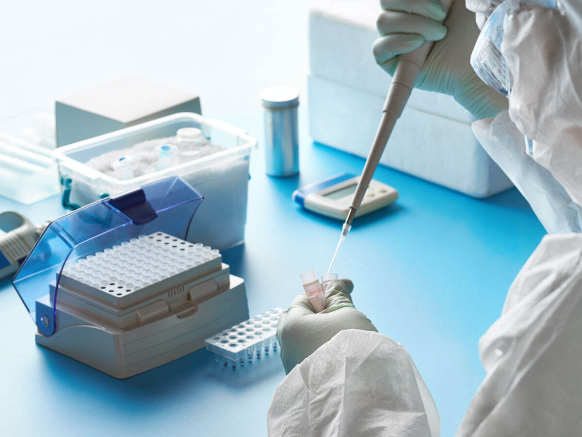Scientist adding fluid to a test tube