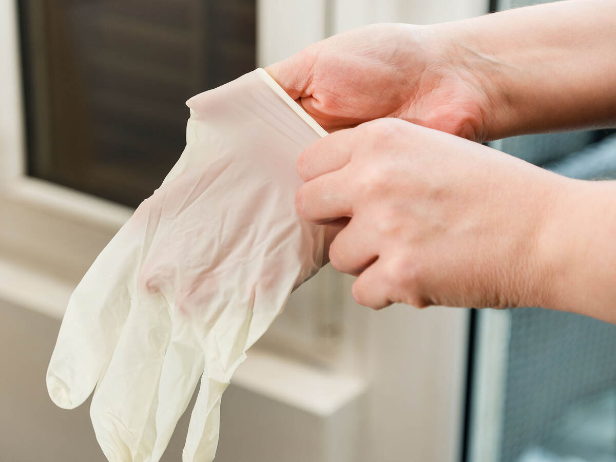 A person putting on latex gloves