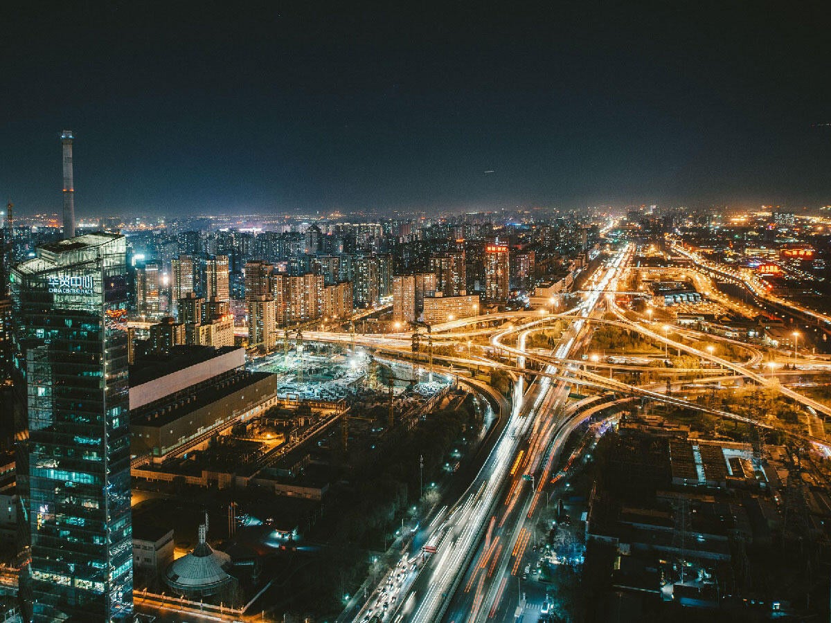 Lit city skyline with highways at night