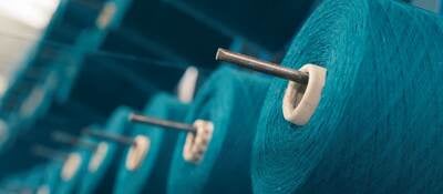 Colored yarn spools of industrial warping machine in textile factory