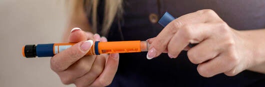 Woman holding insulin injector pen