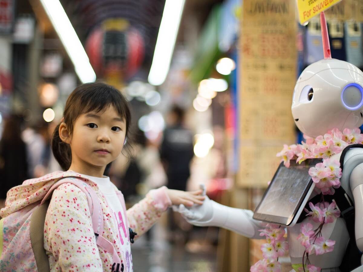 Kid holding hands with a robot
